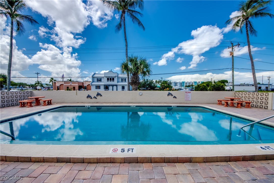 909 Southeast 46th Lane, Unit 202 Cape Coral, FL 33904 - Photo 33 of 38 a view of swimming pool with outdoor seating