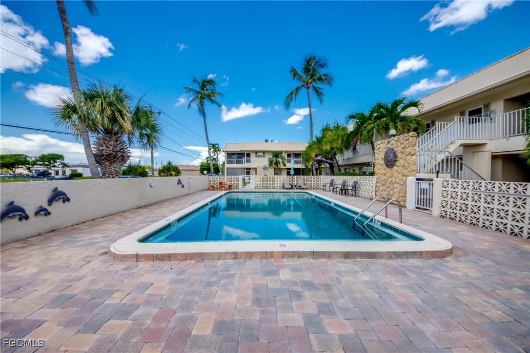 909 Southeast 46th Lane, Unit 202 Cape Coral, FL 33904 - Photo 35 of 38 a swimming pool with outdoor seating and yard
