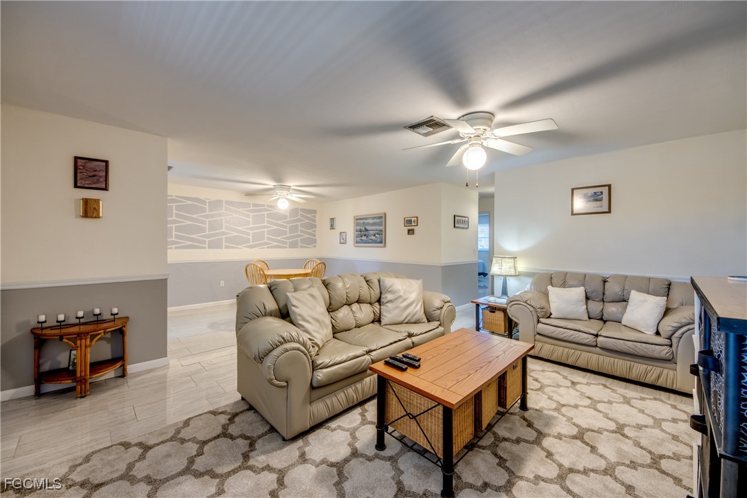 909 Southeast 46th Lane, Unit 202 Cape Coral, FL 33904 - Photo 7 of 38 a living room with furniture and a chandelier