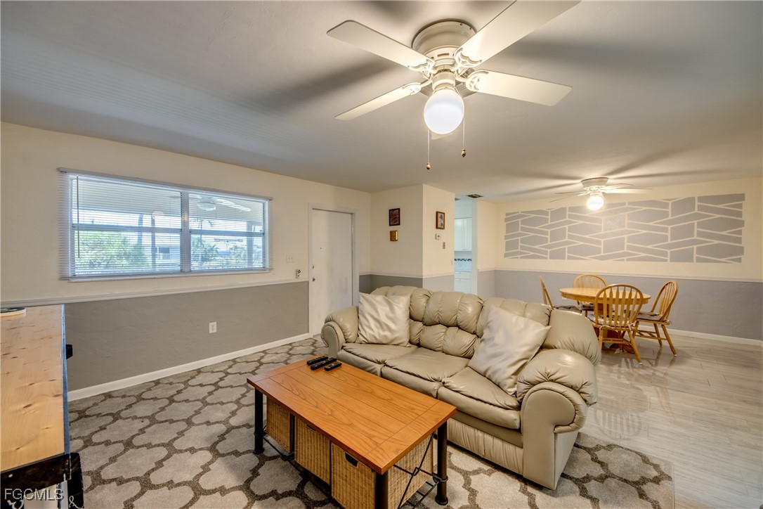 909 Southeast 46th Lane, Unit 202 Cape Coral, FL 33904 - Photo 9 of 38 a living room with furniture a chandelier and a window