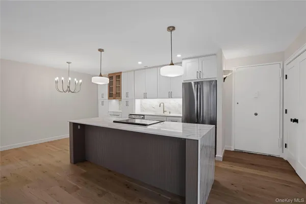 a kitchen with stainless steel appliances a refrigerator a sink and wooden floor