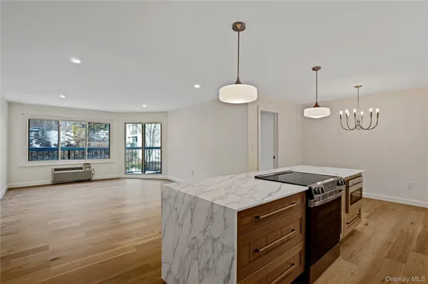 a kitchen with granite countertop a stove and a wooden floors