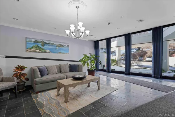 a living room with furniture chandelier and a large window