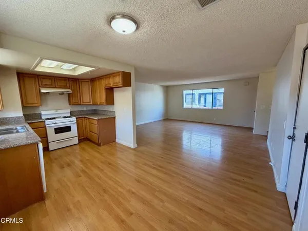 a view of a kitchen with microwave and wooden floor