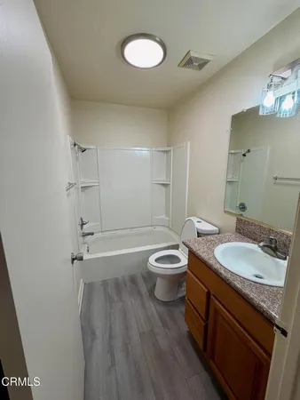 a bathroom with a granite countertop toilet sink and mirror