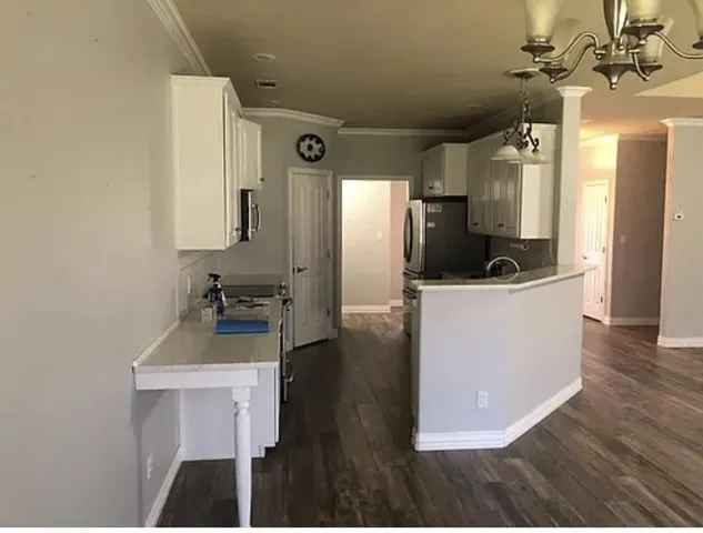 a very nice looking room with wooden floor and ceiling fan