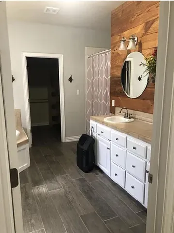 a spacious bathroom with a mirror and a sink