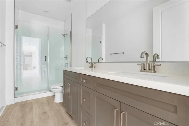 a bathroom with a double vanity sink toilet and shower