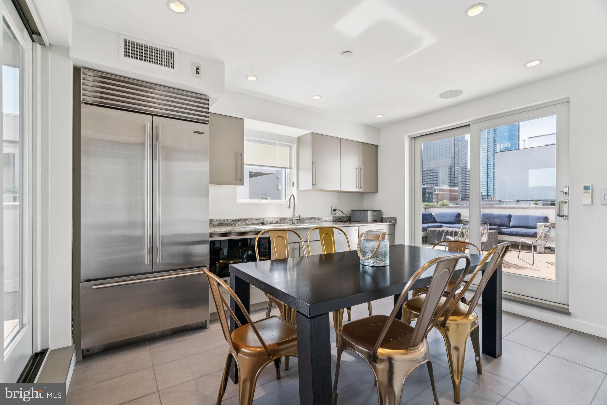 206 North 22nd Street, Unit E Philadelphia, PA 19103 - Photo 46 of 50 a kitchen with a table chairs refrigerator and microwave