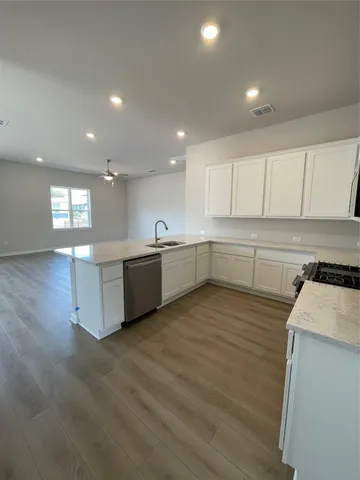 a large kitchen with stainless steel appliances granite countertop a large counter top a sink and a stove