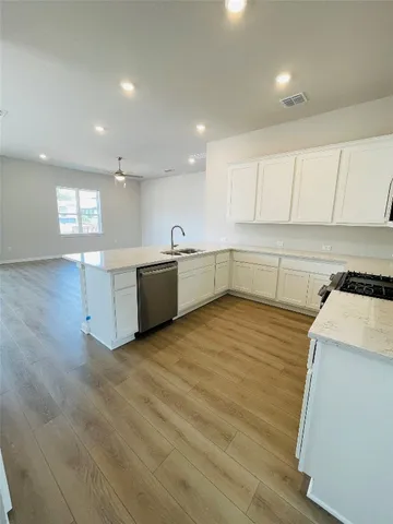 a large kitchen with stainless steel appliances granite countertop a sink and cabinets