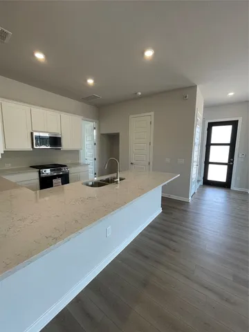 a kitchen with stainless steel appliances granite countertop a sink a stove and a refrigerator