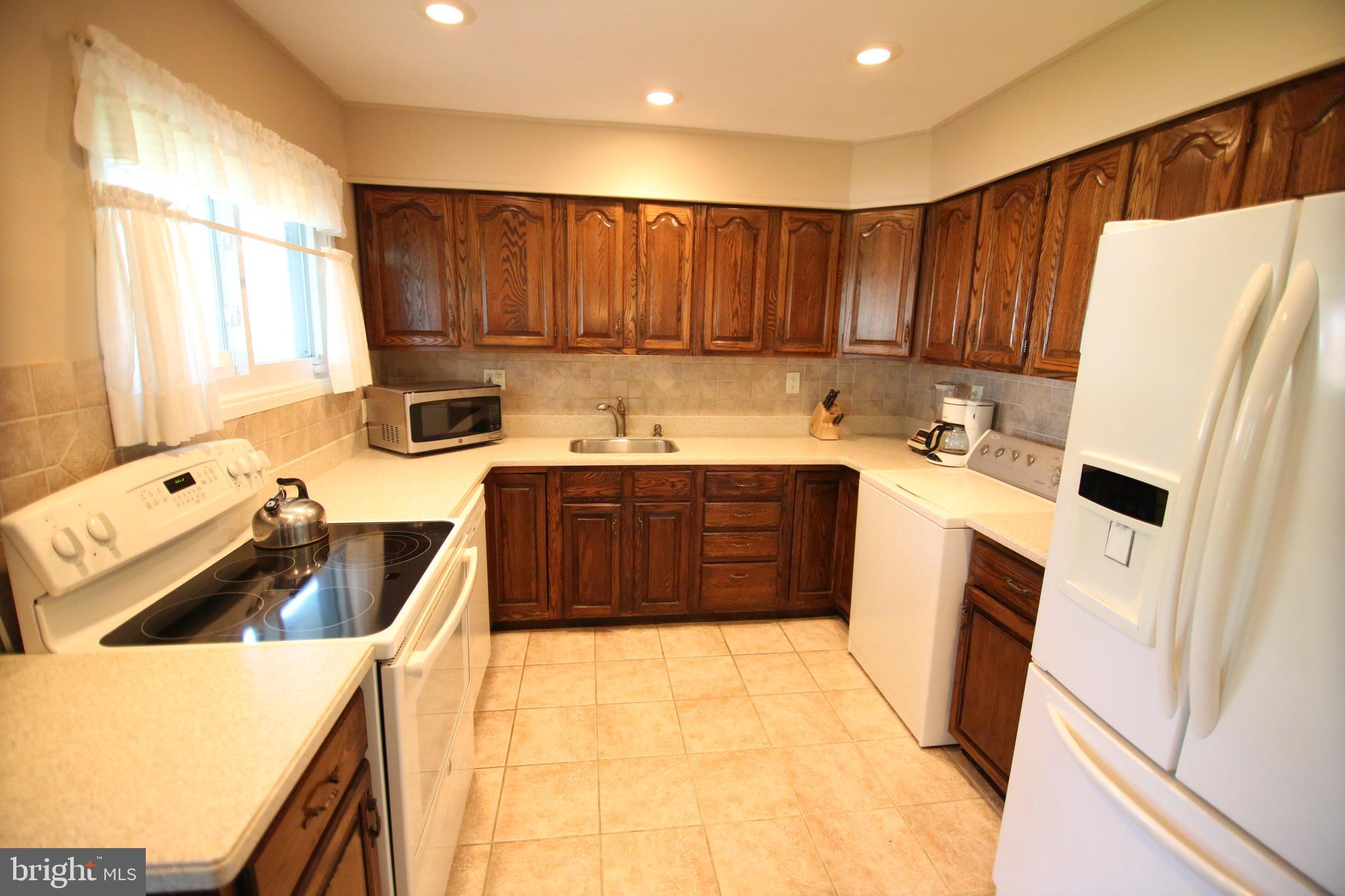 47 Trellis Road Levittown, PA 19056 - Photo 7 of 34 a kitchen with a sink a stove and a refrigerator