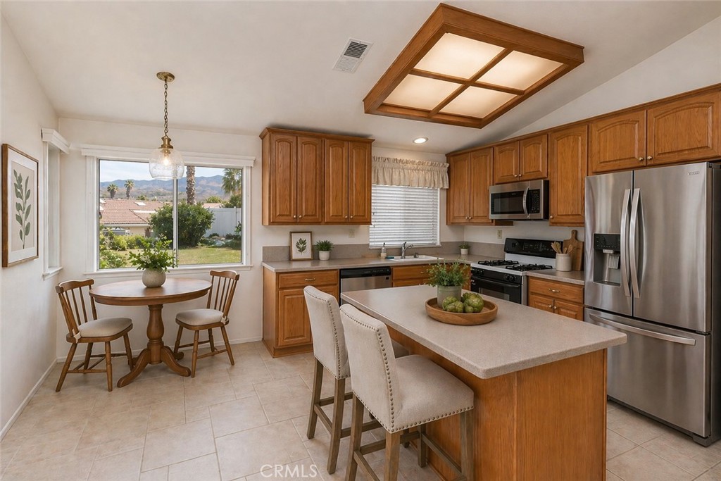 44194 Meadow Grove Street Hemet, CA 92544 - Photo 13 of 42 a kitchen with a dining table chairs and refrigerator