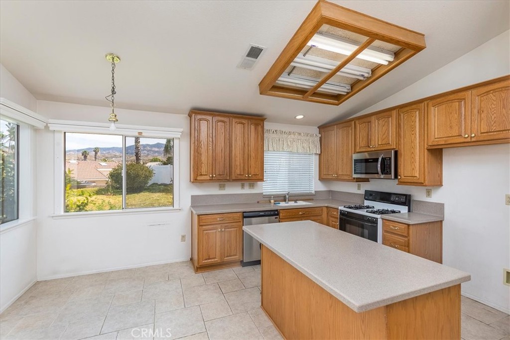 44194 Meadow Grove Street Hemet, CA 92544 - Photo 14 of 42 a kitchen with a stove a sink and a refrigerator