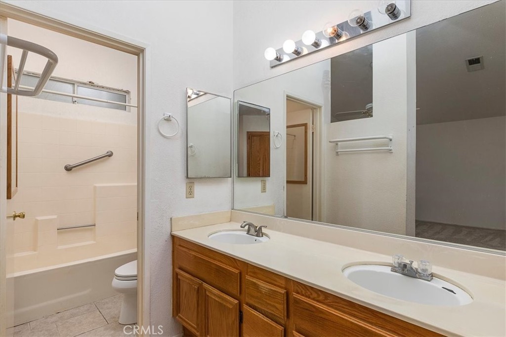 44194 Meadow Grove Street Hemet, CA 92544 - Photo 19 of 42 a bathroom with a sink a toilet a mirror and shower