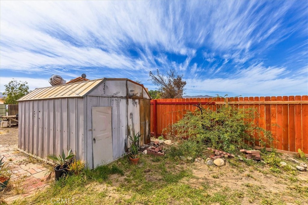 44194 Meadow Grove Street Hemet, CA 92544 - Photo 40 of 42 a backyard of a house with lots of green space and wooden fence