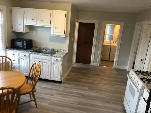 a kitchen with stainless steel appliances granite countertop a stove a sink dishwasher and a refrigerator with wooden cabinets