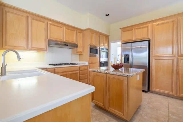 a kitchen with stainless steel appliances a refrigerator sink and cabinets