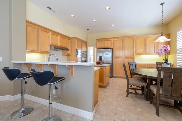 a kitchen with a dining table chairs sink and a window