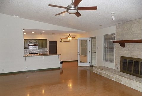509 Meadowbrook Drive Georgetown, TX 78628 - Photo 11 of 17 A great room offers gleaming hardwood floors and a striking stone fireplace.