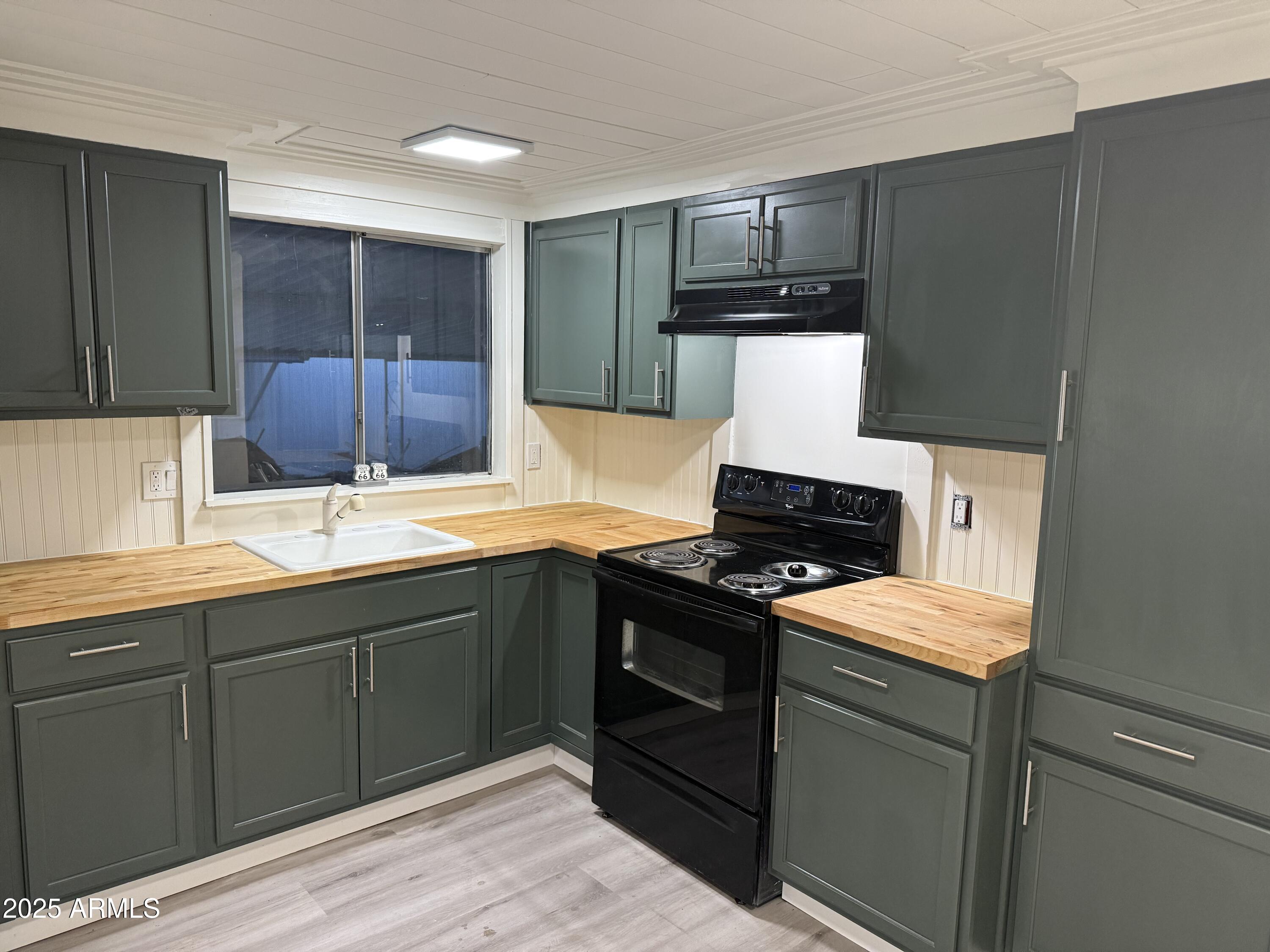 16005 North 32nd Street, Unit 66 Phoenix, AZ 85032 - Photo 4 of 7 a kitchen with a sink and a stove