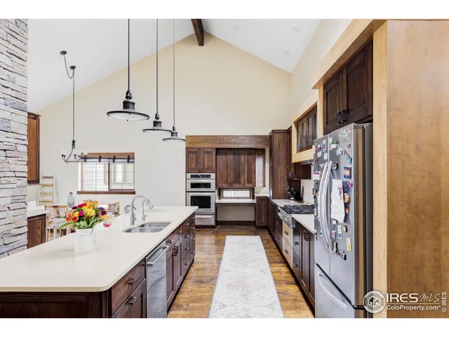 a kitchen with stainless steel appliances kitchen island granite countertop a refrigerator a sink a stove and a refrigerator