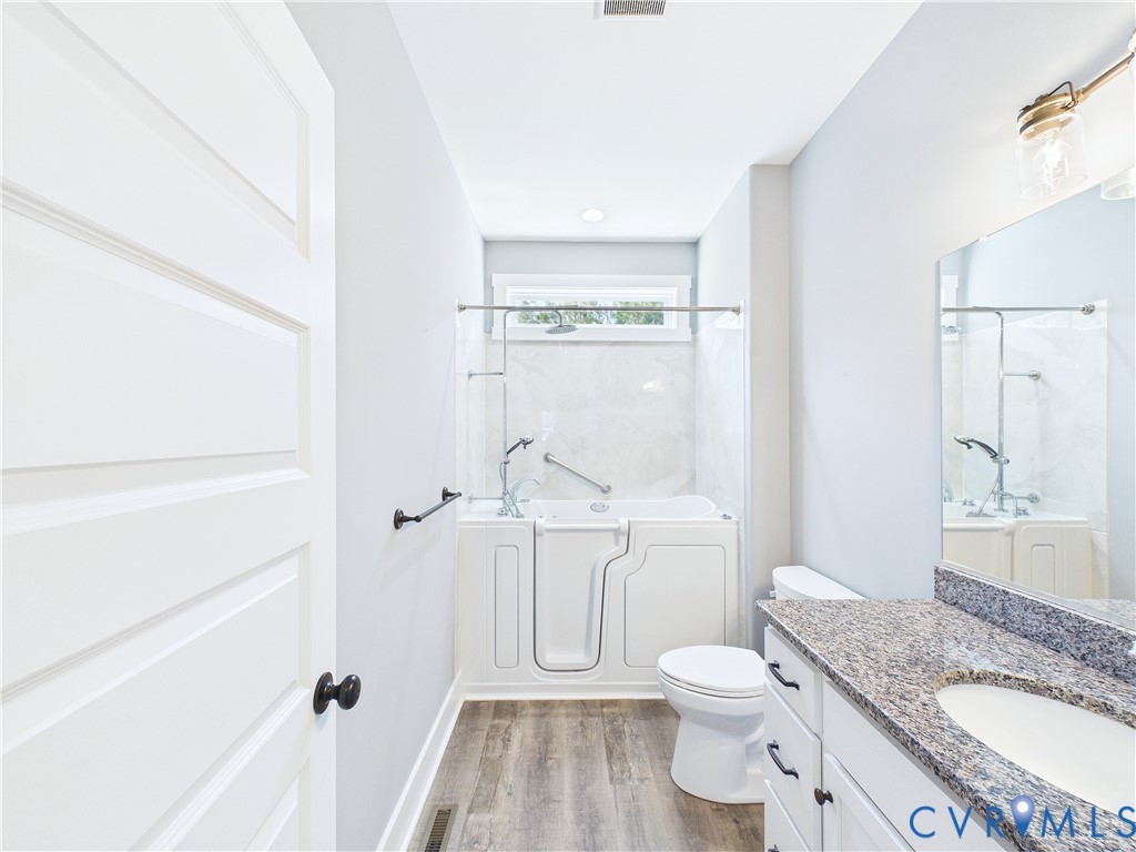 6795 Darlington Heights Road Cullen, VA 23934 - Photo 30 of 44 a bathroom with a granite countertop toilet a sink and a shower
