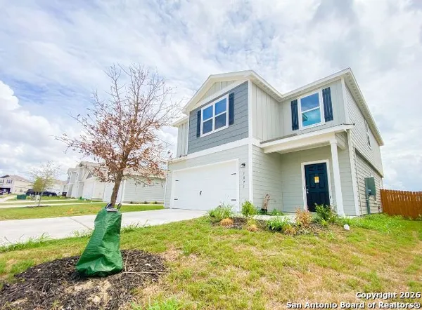 a view of a house with a yard and palm trees