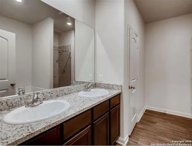 a bathroom with a granite countertop sink and a mirror