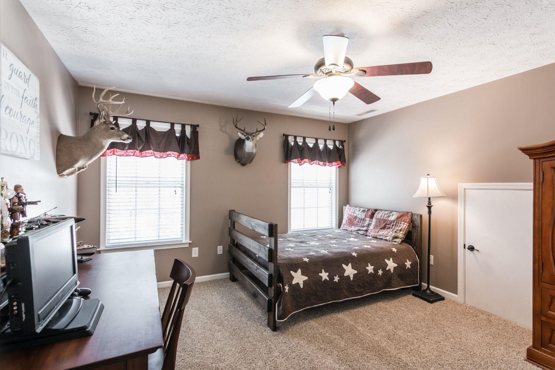 243 Village Green Road Gallatin, TN 37066 - Photo 18 of 24 a bedroom with a bed a window and a flat screen tv