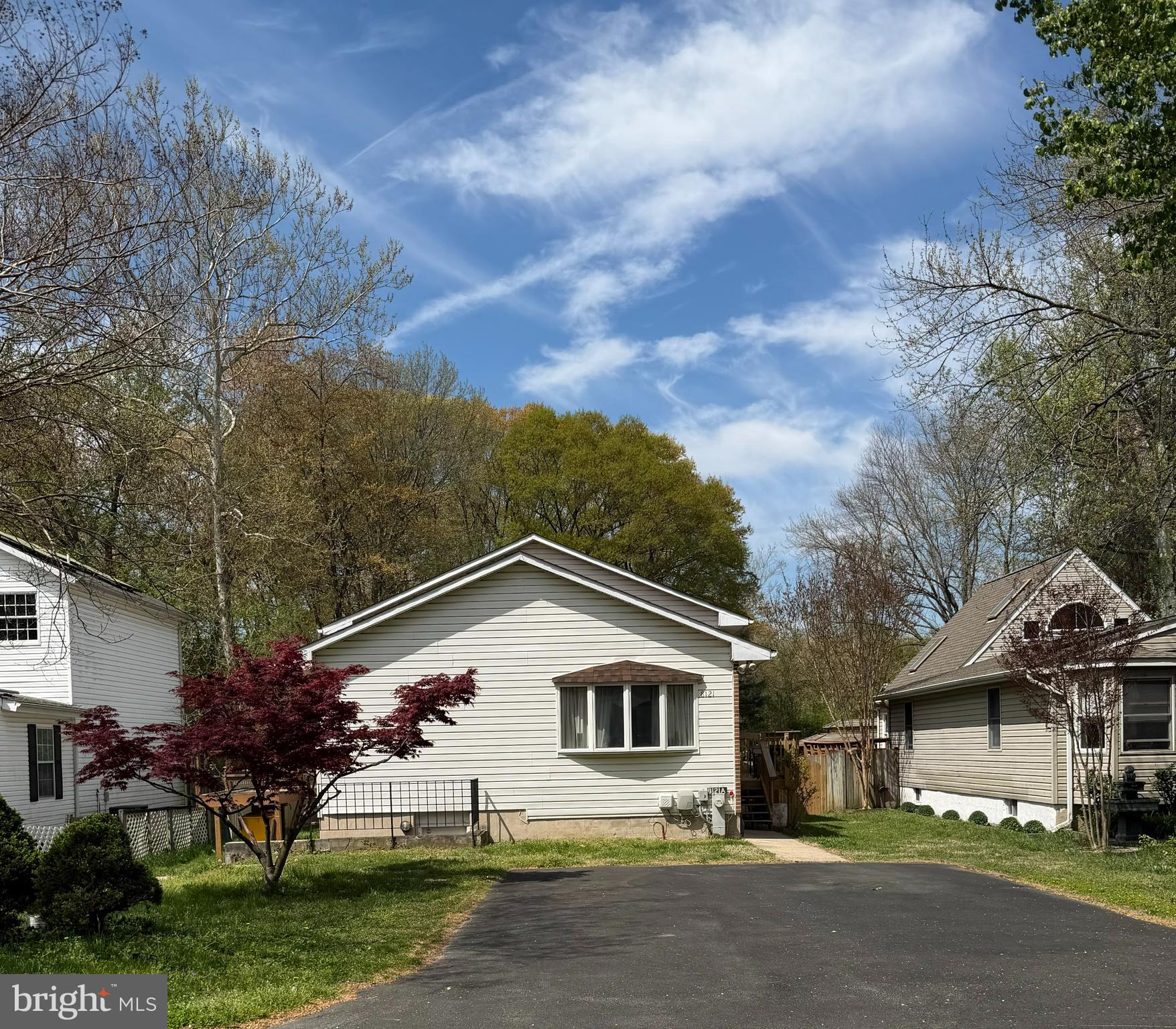 8121 Elizabeth Road Pasadena, MD 21122 - Photo 2 of 27 a view of a white house next to a yard with big trees