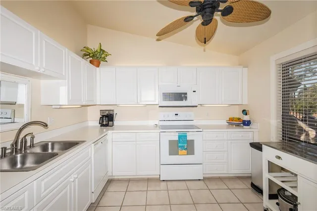 a kitchen with a white cabinets stove and white countertops with wooden floor