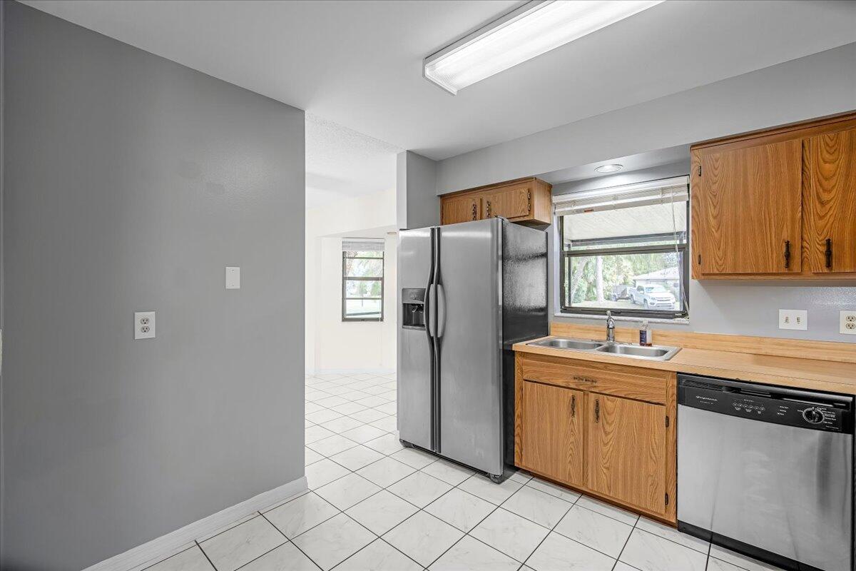 4514 Seattle Street Cocoa, FL 32927 - Photo 18 of 34 a kitchen with stainless steel appliances a refrigerator sink and microwave
