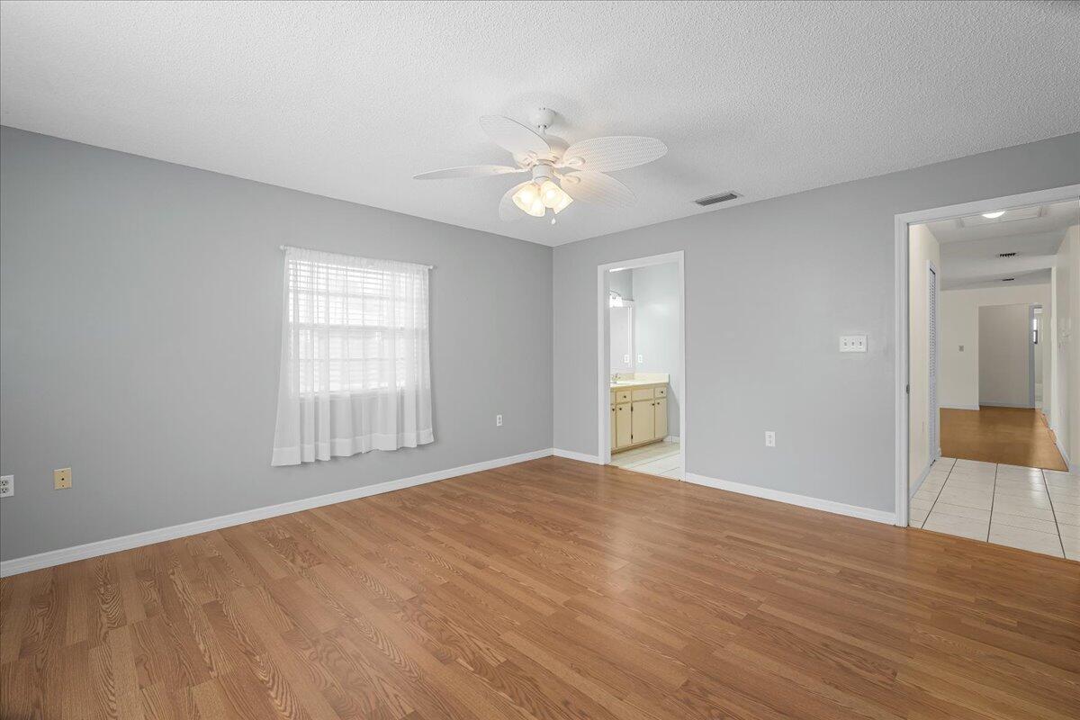 4514 Seattle Street Cocoa, FL 32927 - Photo 22 of 34 an empty room with wooden floor fan and windows