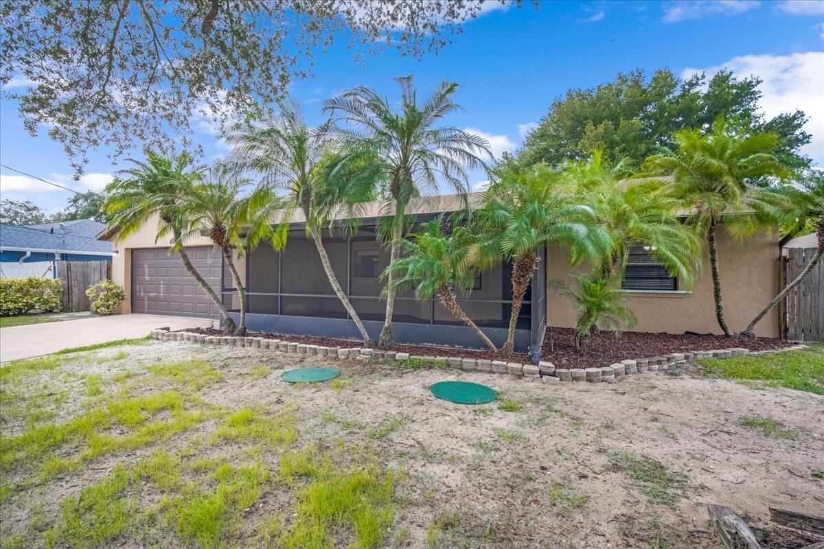 4514 Seattle Street Cocoa, FL 32927 - Photo 3 of 34 a backyard of a house with potted plants and palm trees
