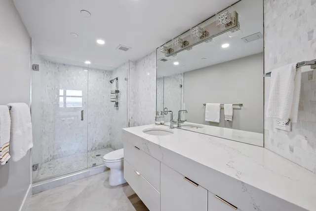 a bathroom with a sink vanity mirror and toilet