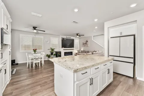 a kitchen with stainless steel appliances granite countertop a sink stove cabinets and a wooden floor