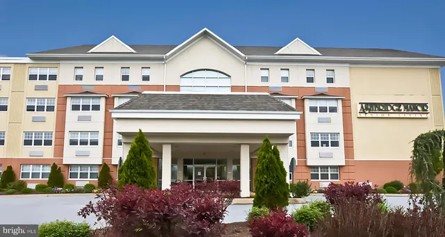 a view of a white house with large windows and a flower garden