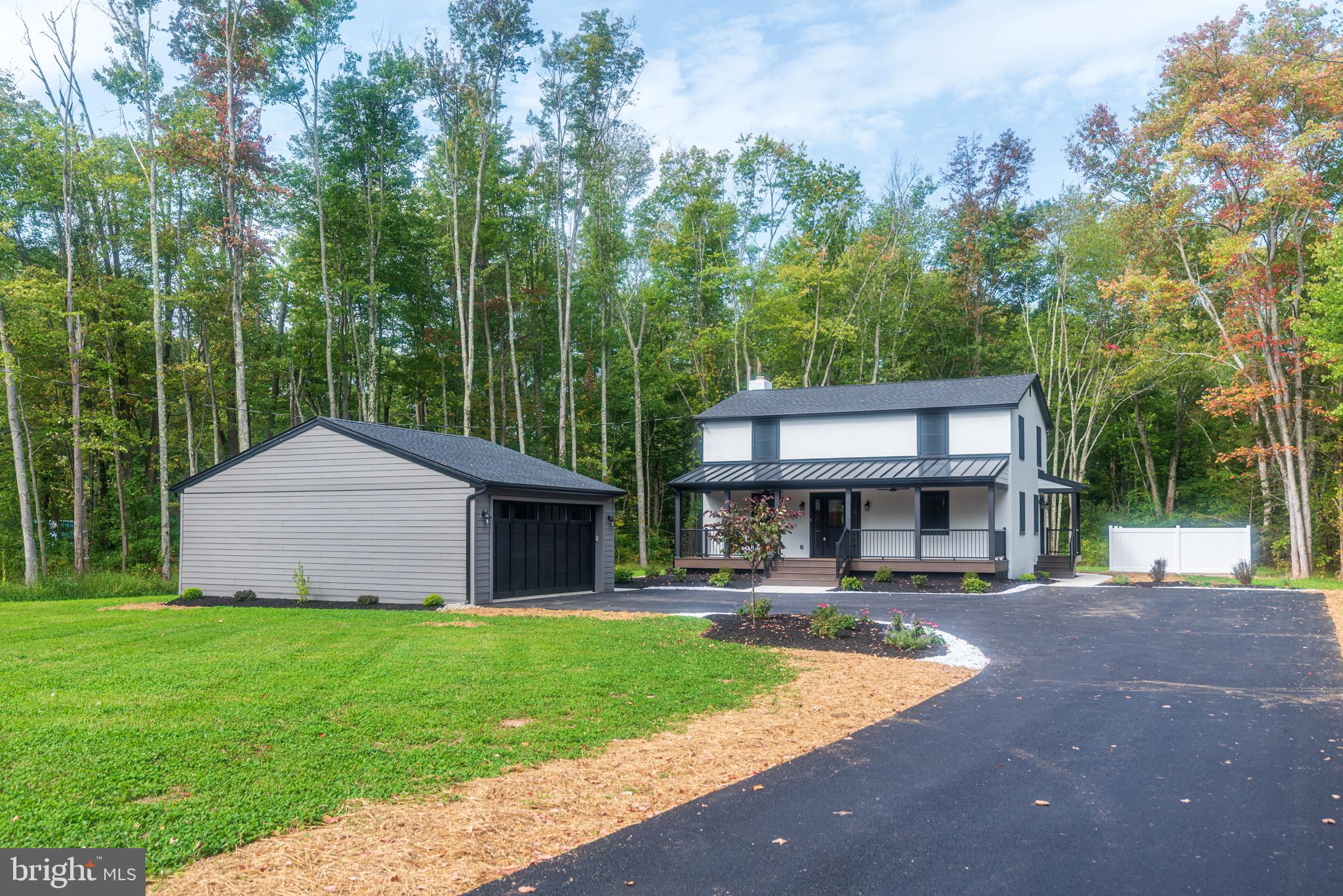 a front view of a house with a yard and trees