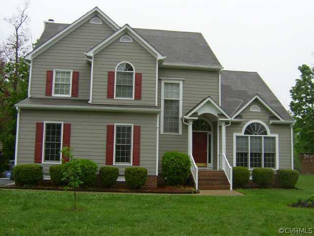 a view of a brick house with a yard potted plants and a large window