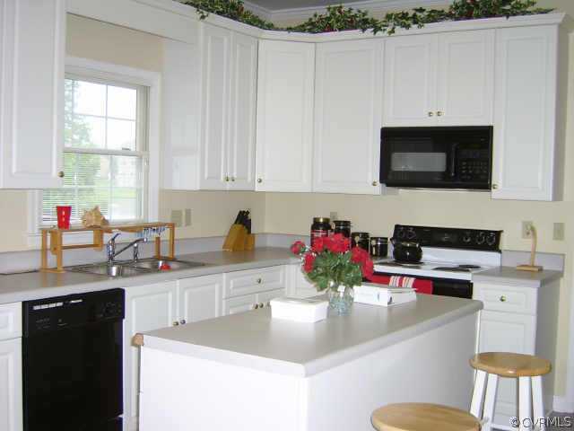 11630 Stephens Point Drive Chester, VA 23831 - Photo 4 of 10 a kitchen with stainless steel appliances a sink a stove a microwave a sink and cabinets