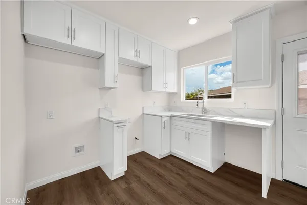 a kitchen with a sink cabinets and wooden floor