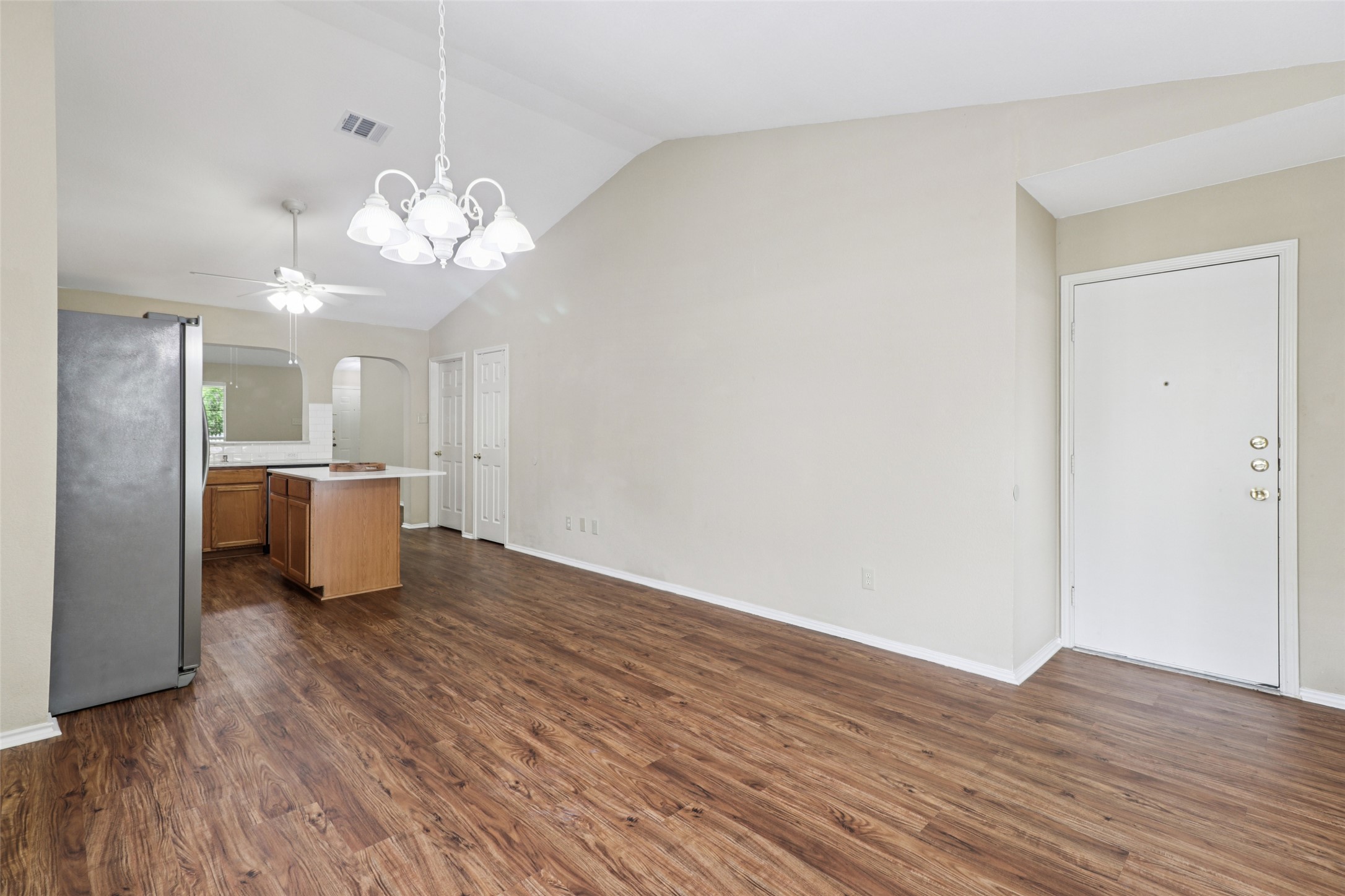 700 Scheel Road Kyle, TX 78640 - Photo 19 of 39 Living area featuring vaulted ceilings, a decorative chandelier, and wood-look flooring