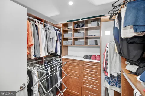 a view of walk in closet with clothes and shoes