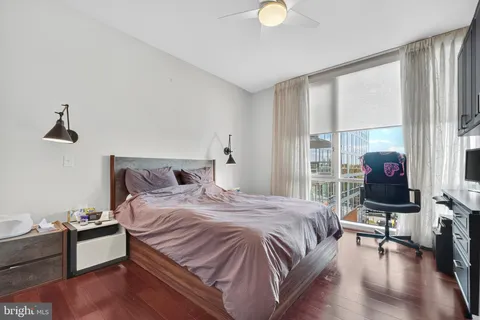 a bedroom with a bed wooden floor and a window
