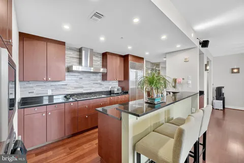 a kitchen with granite countertop kitchen island stainless steel appliances a sink and cabinets