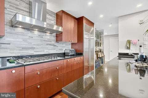 a kitchen with stainless steel appliances granite countertop a sink stove and refrigerator