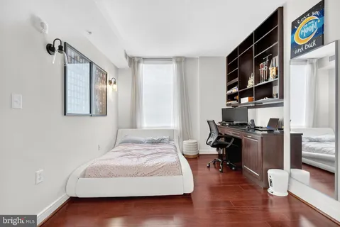 a bedroom with a bed and a computer on a table