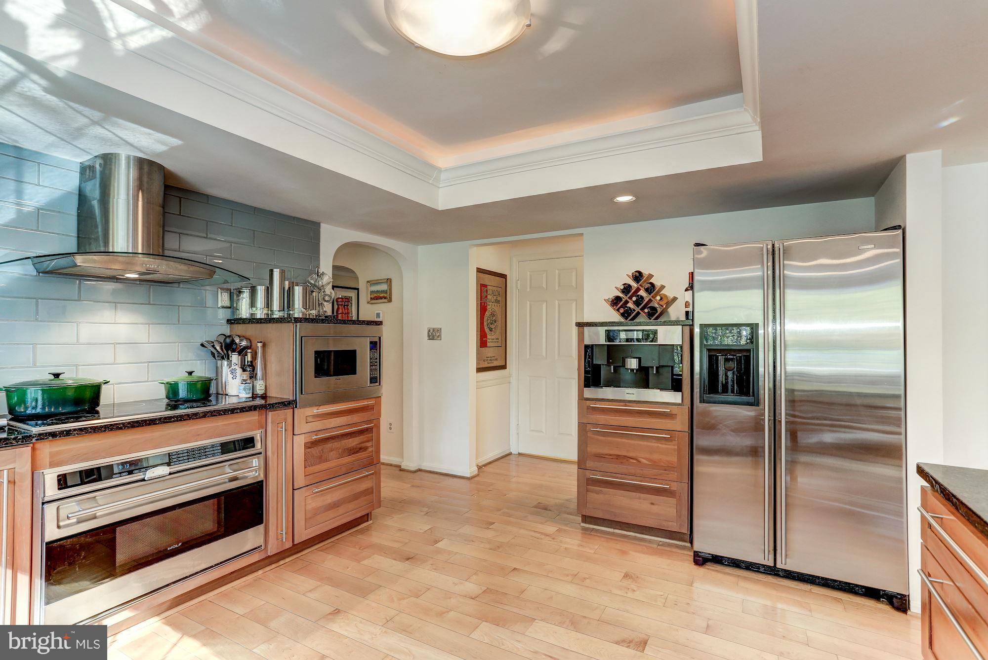 2232 Wakerobin Lane Reston, VA 20191 - Photo 5 of 30 a kitchen with stainless steel appliances kitchen island granite countertop a refrigerator and a stove top oven